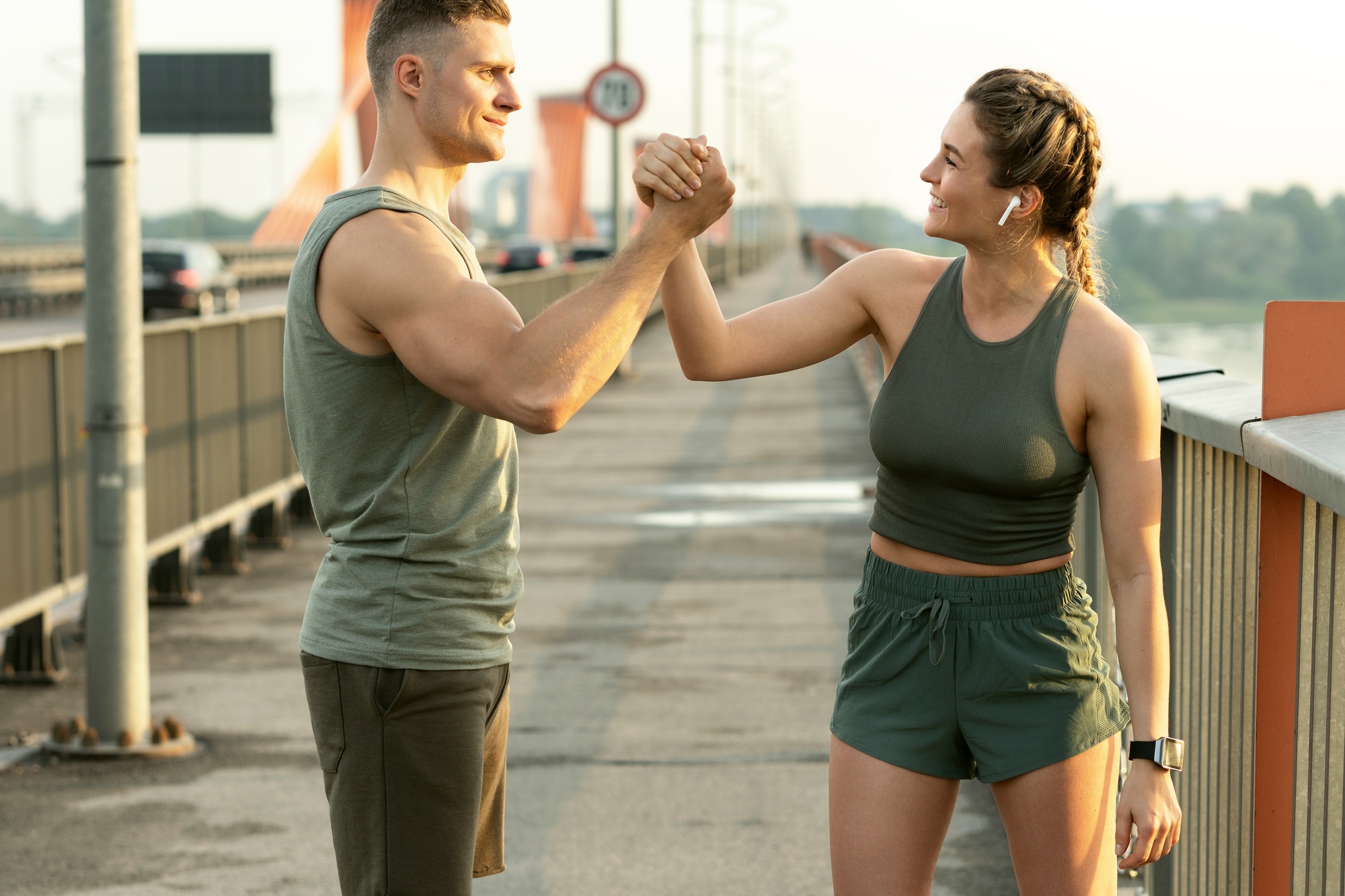Athletic couple making handshake during fitness workout on city street